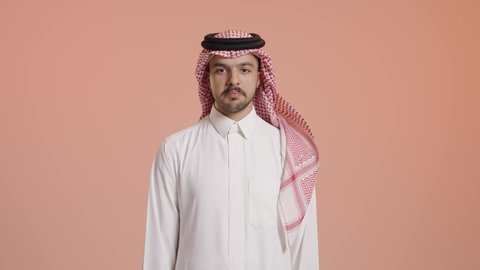 التعبير عن الإعجاب والتقدير، رفع اليد بعلامات الجودة والقبول، الامتياز والعلامة الكاملة، الشعور بالرضا والاستحسان، بورتريه لرجل عربي خليجي سعودي مبتسم يرتدي الثوب التقليدي والشماغ ينظر إلى الكاميرا بإيماءات السعادة والسرور