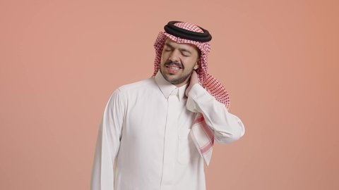 آلام العنق والعمود الفقري, الحاجة للعلاج الفيزيائي، الإحساس بالتعب والإرهاق, وجع مفاصل و عظام الرقبة, بورتريه لشاب عربي خليجي سعودي يرتدي الشماغ والثوب التقليدي يضع يده حول عنقه بإيماءات الألم