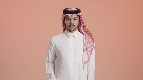 الاشارة بالإصبع الإبهامي علامة لايك, بورتريه لرجل عربي خليجي سعودي بشوش الوجه يرتدي الثوب الأبيض التقليدي مع شماغ وعقال و يقوم بعلامة الموافقة بالإبهام, مفهوم لغة الجسد وتعابير الوجه