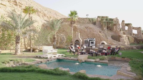 تصميم هندسي وفني لمنتجع ترفيهي عصري، مسبح خارجي محاط بالنخيل والمجالس التراثية،  أجواء استرخاء في الهواء الطلق