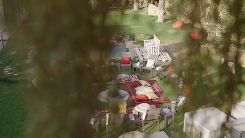 تصوير لحديقة تحتوي على جلسة عربية تراثية ومسبح حجري، أجواء استجمام واسترخاء، ديكور خارجي تقليدي