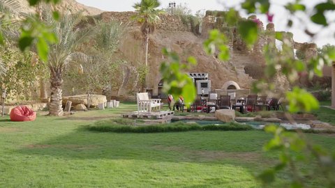 أجواء مريحة تمنح الاسترخاء والسكينة، تصوير لحديقة تحتوي على جلسة عربية تراثية ومسبح حجري، ديكور خارجي تقليدي