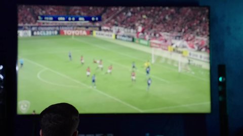 قضاء وقت الفراغ بمشاهدة التلفاز ، الانتصار و تحقيق الأهداف، شاب عربي خليجي سعودي يرتدي الزي الكاجوال يحمل بيديه كره القدم و يحتفل بفوز فريقة المفضل، ايماءات الحماس والسعادة والسرور