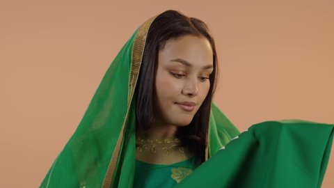 Celebrating Saudi National Day September 23, Flag Day March 11, wearing the traditional costume of the central region on a national occasion, Badina Day February 22, close-up portrait of a Saudi Arabian Gulf woman wearing a sheila and bisht kissing the flag of the Kingdom, floral background