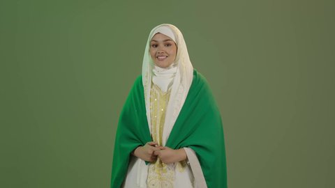 يوم العلم 11 مارس، شعار الهوية الوطنية وراية الإسلام والتوحيد، الأزياء الشعبية التقليدية، اليوم الوطني السعودي 23 سبتمبر، بورتريه لامرأة عربية خليجية سعودية مبتسمة ترتدي الشيلة والنشل تضع علم المملكة على كتفيها، ارتداء زي المنطقة الشرقية، خلفية خضراء، كروما