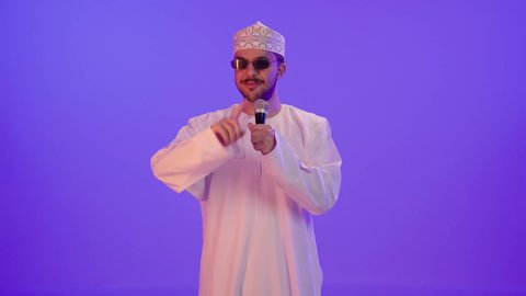 مواهب فنية في عالم الموسيقى, تقديم العروضات المسرحية, الفن المسرحي الغنائي, الغناء بحماس وصوت عالي، بورترية لشاب عربي خليجي عماني يرتدي الدشداشة و الكمه و النظارة الشمسية يقوم بممارسة هواية الغناء للتسلية والترفيه يحمل بيده الميكروفون، إيماءات وتعابير الاندماج و السعادة , خلفية بنفسجية