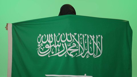 تأسيس الدولة السعودية الأولى 22 فبراير، ذكرى يوم بدينا 1727 م, بورتريه لإمرأة عربية خليجية سعودية سمراء ترتدي علم المملكه على ظهرها  بتعابير الفخر والاعتزاز,ذكرى العيد الوطني السعودي 23 سبتمبر، خلفية خضراء