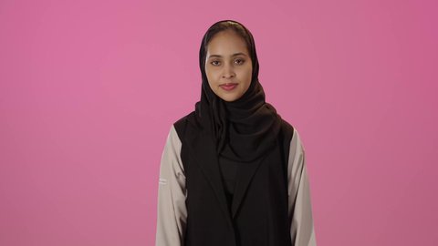 تعابير عن التميز والامتياز بإشارة لحالة ممتازة, بورتريه لشابة عربيه خليجيه سعودية سمراء محجبه ترتدي الزي الكاجوال تشير بإيماءات القبول والامتياز, علامة الجودة والإتقان, النظر الى الكاميرا بسعادة وسرور ، خلفية ملونه