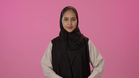 اظهار مشاعر الحب والشغف، ايماءات يدين على شكل قلب، مفهوم المحبة والمودة، بورتريه لشابة عربيه خليجيه سعوديه محجبة سمراء ترتدي الزي الكاجوال تنظر إلى الكاميرا بتعابير السرور والسعادة، خلفية ملونه