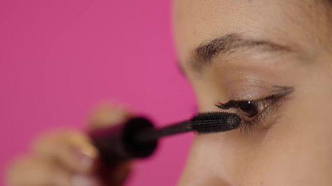 ادوات مكياج تتوريال، بورترية مقرب من الجانب لامراة عربية خليجية سعودية سمراء تحمل (قلم المسكرة) لإبراز العين، التسويق لمنتجات التجميل، متجر بيع مستحضرات التجميل عبر الإنترنت، مفهوم الإهتمام بالجمال والبشرة، صالون تجميلي نسائي