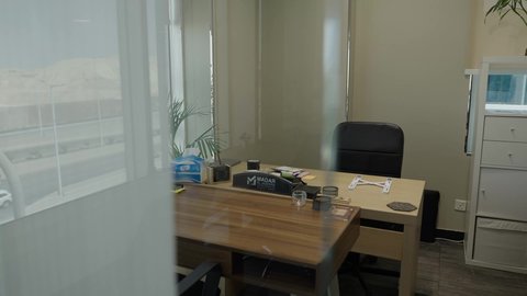 Modern offices with a glass-fronted view of the main street. A calm and well-equipped office environment that promotes productivity and creativity. Saudi profession and job. Gulf offices and companies.