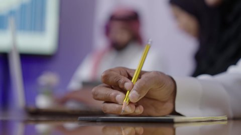 الاتفاق على المشروع التجاري، مكاتب و شركات خليجية، توقيع عقد صفقة جديدة، تصوير مقرب ليد رجل عربي سعودي خليجي يجلس في المكتب داخل مقر الشركة,  مهنة ووظيفة سعوديه