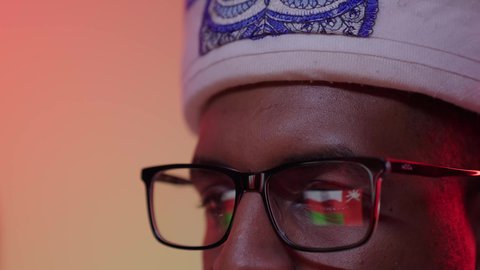 مفهوم حب الوطن والانتماء اليه ،ذكري عيد الاستقلال والتأسيس 18 نوفمبر، انعكاس صورة علم عمان على عدسة النظاره  ،  تصوير مقرب لعين رجل عربي خليجي عماني اسمر يرتدي نظاره طبيه ، ينظر بفخر الى علم سلطنه عمان