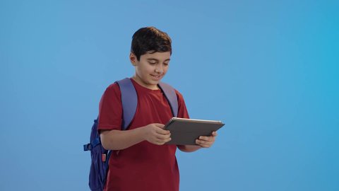 E-learning in Saudi Arabia, browsing the internet and chatting, communicating with friends, children using modern technology, a Saudi Gulf Arab boy using a tablet, making a video call