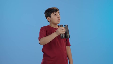 استخدام المنظار وحب الاستكشاف والمغامرة، التخطيط للأهداف والطموحات المستقبلية، ايماءات الاندهاش والذهول ، ولد عربي خليجي سعودي يرتدي الزي الكاجوال يقوم بالنظر من خلال المنظار، رؤية الأشياء البعيدة باستخدام التلسكوب