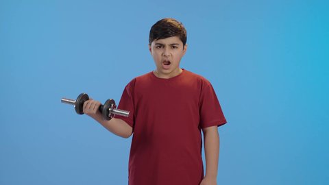 ممارسة التمارين الرياضية مع الدمبل، نشاط بدني للمحافظة على الصحة واللياقة الجسدية، أسلوب حياة صحي، بورتريه لولد عربي خليجي سعودي يرتدي الزي الكاجوال ، تمارين رفع الأثقال (دمبلز)، رفع الأوزان الحديدية الثقيلة