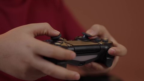 تصوير مقرب  لولد عربي خليجي سعودي يرتدي الزي الكاجوال يجلس على كرسي متحرك يحمل بيده عصا التحكم، استخدام جهاز تكنولوجي تقني حديث ومتطور، قضاء وقت ممتع في ألعاب الفيديو الترفيهيه،إيماءات الاستمتاع والاندماج