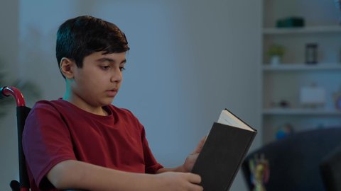 تصفح الكتب العلميه، الشغف بالعلم والثقافه ، الاستمتاع بممارسة هواية المطالعة،ولد عربي خليجي سعودي يجلس على كرسي متحرك  يقوم بقراءة القصص