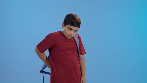 مفهوم العودة إلى المدارس, النظر إلى الكاميرا بإيماءات السعادة و السرور, الاستعداد للعام الدراسي الجديد, بورتريه لولد عربي خليجي سعودي يرتدي الزي الكاجوال وشنطه مدرسيه