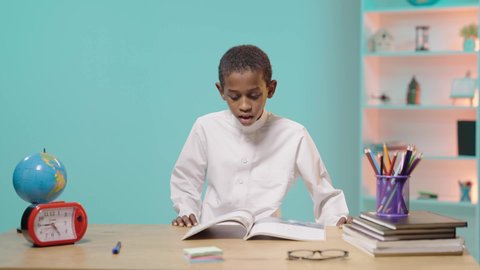 متابعة المناهج الدراسية,  الشعور بالتعب والنعاس من الدراسة، طالب عربي خليجي سعودي يرتدي الزي التقليدي يأخذ غفوه على المكتب، دخول وقت النوم ، الحاجه الى الراحه