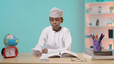 راحة بعد يوم طويل, مفهوم تنظيم و إدارة الوقت, أهمية النوم الجيد في تعزيز الصحة العقلية والجسدية للطلاب، طالب عربي خليجي عماني يرتدي الدشداشة والكمة نائم على الطاولة بعد الدراسة, خلفية زرقاء