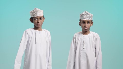 Thumbs up, facial and hand gestures indicating admiration and satisfaction, and a picture of two Omani Gulf Arab boys wearing dishdashas and kummah making the like sign, blue background