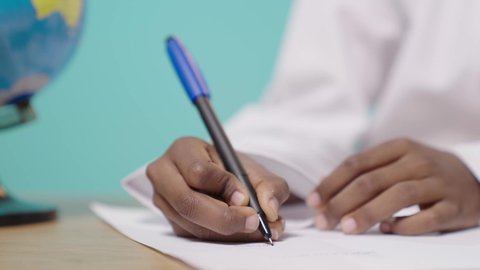 استخدام ورقة بيضاء في الدراسة, مراجعة الدروس بجد واجتهاد للوصول إلى النجاح والتفوق، العودة إلى المدارس, بورتريه ليد ولد عربي خليجي عماني يقوم بالكتابة و حل الواجب المدرسي, خلفية زرقاء