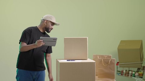 تاكيد الحجوزات عبر جهاز التابلت, خدمة التوصيل السريع والآمن في السعودية، بورتريه لمندوب عربي خليجي سعودي يرتدي الزي الكاجوال و قبعة بيج يحمل الجهاز اللوحي و يباشر عمله, الاستفادة من التكنولوجيا الحديثة بتسهيل العمل، خلفية خضراء