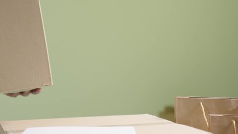 بورتريه مقرب ليد رجل عربي خليجي سعودي يضع صندوق كرتون, عملية شحن و توصيل موثوقة, التسوق و طلب المنتجات عبر الإنترنت، خلفية خضراء