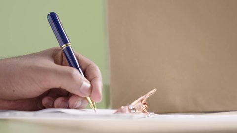 مهنة مندوب التوصيل بكتابة المنتجات المطلوبة، بورتريه مقرب ليد رجل عربي خليجي سعودي يرتدي الزي التقليدي يقوم بتسجيل بيانات الشحنة، أوراق و مستندات استلام و تسليم الطرد, خدمة الشحن و التوصيل ذات الجودة العالية