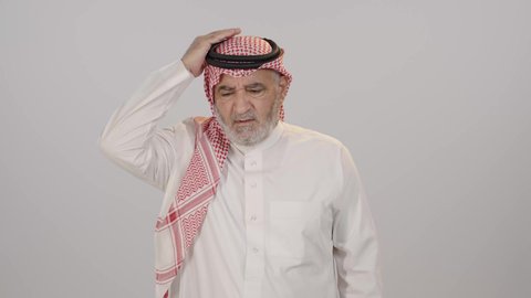 الاجهاد والضغط النفسي, الاحساس بالشقيقية والصداع النصفي, بورتريه لرجل مسن عربي خليجي سعودي يرتدي الثوب التقليدي و الشماغ يضع يديه على رأسه بإيماءات المرض و الحاجة الى العلاج والراحة