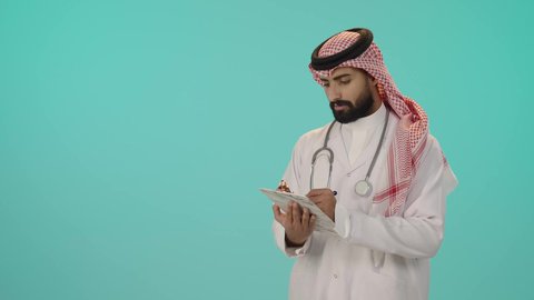 مفهوم الرعاية الصحية في السعودية، بورتريه لطبيب عربي خليجي سعودي يرتدي الزي التقليدي و الشماغ مع المعطف الأبيض يضع سماعة الفحص يقوم بالكتابة على ملف, تقديم الخدمات العلاجية في المراكز الطبية والمستشفيات, تدوين و تسجيل معلومات و ملفات المرضى, خلفية زرقاء