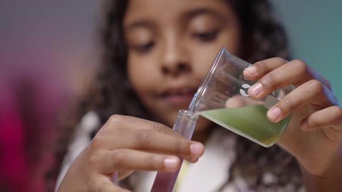 تجارب و أبحاث علمية مخبرية، تصوير لبنت عربية خليجية سعودية سمراء ترتدي المعطف الطبي الأبيض تقوم بإجراء تحاليل طبية كيميائية بأنابيب إختبار التفاعلات الكيميائية ،اجراء التحاليل الطبية ، المختبر الطبي و معمل الكيمياء ، مفهوم مهن مستقبلية ، ايماءات الاندماج و التركيز