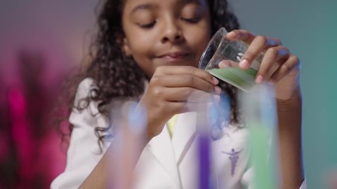 مختبر و معمل الكيمياء، مفهوم المهن مستقبلية، تصويرمقرب لبنت عربية خليجية سعودية سمراء  ترتدي المعطف الطبي الأبيض تقوم بتجارب و أبحاث علمية مخبرية ، إجراء التحاليل الطبية، خلفية بيضاء