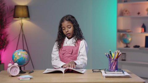 أهمية الراحة والنوم الجيد في تعزيز الصحة العقلية والجسدية للطلاب، التعب والاجهاد أثناء المذاكرة، تصوير لبنت عربية سعودية خليجية سمراء ترتدي الزي المدرسي تضع يدها على فمها تقوم بالتثاؤب أثناء مذاكرتها للدروس، الدراسة لساعات متأخرة في الليل