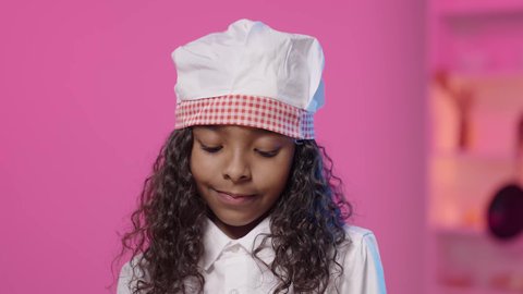 ايماءات الاندماج و التركيز، احتراف الطهي وفنون تقديم المأكولات، تصويرمقرب لفتاه عربية خليجية سعودية سمراء ترتدي زي الشيف الخاص  تنظر الى الاسفل ، مهن و وظائف مستقبلية