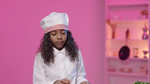 مفهوم القبول والموافقه، تعابير الإعجاب والرضى، فنون الطهي وإبداع إعداد الطعام، تصوير لفتاه عربية خليجية سعودية سمراء ترتدي زي الشيف الخاص تشير باصبعها الابهام الى الاعلى ، النظر الى الكاميرا بايماءات السعادة و السرور ، مهن و وظائف مستقبلية