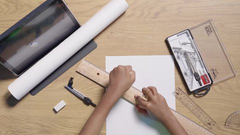 التخطيط والدراسة الأكاديمية، تصوير مقرب ليد بنت عربية خليجية سعودية تستخدم أدوات هندسية على مكتب خشبي ، مخططات و تصماميم هندسية ، مفهوم المهن مستقبلية ، التدريب على الرسم الفني