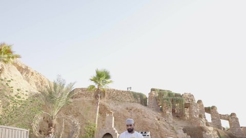 اكتساب المعرفة وتنمية الذخيرة اللغوية والعلمية، قضاء وقت ممتع في قراءة الكتب والروايات، شاب عربي خليجي عماني مثقف يرتدي الدشداشة والكمة يجلس في إحدى الحدائق العامة يقوم بقراءة كتاب، مفهوم التعلم الذاتي والاطلاع والثقافة، الشغف في ممارسة هواية المطالعة