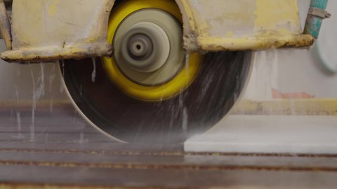 Marble manufacturing and processing, advanced industrial equipment, close-up shot of an electric saw designed for cutting and slicing marble and stone slabs inside the factory.