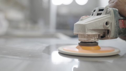 Close-up shot of a Saudi Gulf Arab worker's hand polishing and shining marble, a local national product, in a stone and marble factory in the Kingdom of Saudi Arabia.