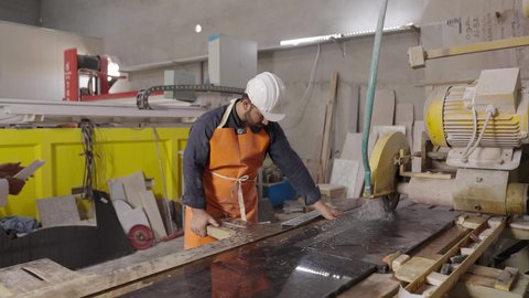 العمل بروح الفريق لإنجاز المهام، تدوين وتسجيل الملاحظات والمعلومات ، تحقيق الثورة الصناعية، مجموعة من المهندسين الصناعيين العرب السعوديين الخليجيين يرتدون ملابس العمل وخوذة الحماية يتابعان سير أعمال المصنع ، جودة الانتاج والتصنيع، مهن ووظائف سعودية