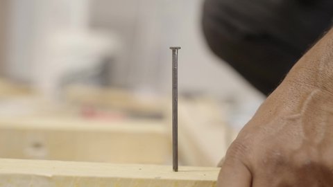 مهن وصناعات يدوية، تصوير مقرب  ليد عامل سعودي يقوم بدق المسامير من خلال مطرقة خشبية، ادوات البناء والنجارة