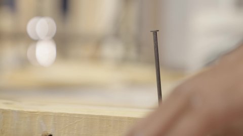 تطبيق الأعمال اليدوية في قطاع الإنتاج، تصوير مقرب  ليد عامل سعودي يقوم بدق المسامير من خلال مطرقة خشبية، ادوات البناء والنجارة، مهن وصناعات يدوية