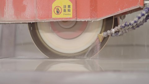 تقنيات حديثة في قطاع الصناعة، منشار كهربائي صناعي مخصص لقص وصقل الرخام الطبيعي، معدات صناعية حديثة، تصوير مقرب لجهاز تقطيع ألواح الرخام في المصنع