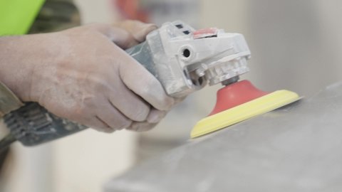 صناعة ومعالجة الرخام، مهن وأعمال يدوية صناعية، تصوير مقرب لعامل عربي خليجي سعودي يستخدم منشار الرخام الصناعي داخل المصنع، تشغيل معدات صناعية