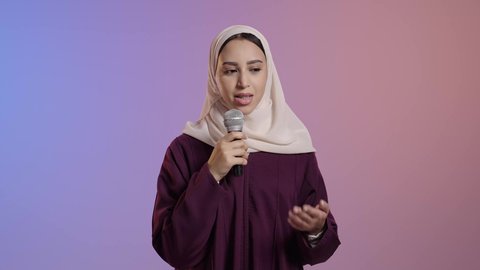 إلقاء المحاضرات وإقامة الندوات، بورتريه لامراة عربية خليجية سعودية محجبه ترتدي العباءة تحمل بيدها الميكروفون ، العمل في تقديم الفقرات و البرامج الفنية, خلفية ملونه