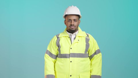 وظائف ومهن سعودية، بورترية لمهندس عربي خليجي سعودي يرتدي الخوذه و ستره الحماية يقف بايدي متقاطعة، الوقوف باستقامة والنظر الى الكاميرا بإيماءات السعادة والسرور, خلفية خضراء