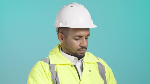 الإشراف على سير أعمال البناء، متابعة تنفيذ المشاريع المعمارية، وظائف ومهن هندسية، العمل في مجال الهندسة الإنشائية، بورترية مقرب لمهندس عربي خليجي سعودي يرتدي سترة وخوذة الحماية يحمل مخطط ورقي يقوم بمتابعة الخطط في موقع العمل، خلفية خضراء