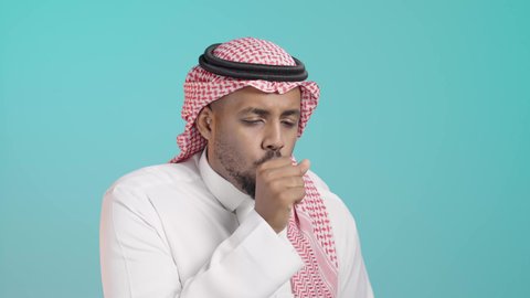 الشعور بالمرض والكحة، الانفلونزا والتهاب الرئة، الاصابة بفايروس كورونا كوفيد19، الحاجة لتلقي العلاج، الاجواء الشتوية الباردة، بورتريه مقرب لرجل عربي خليجي سعودي يرتدي الثوب الابيض و الشماغ يعاني من السعال، خلفية خضراء